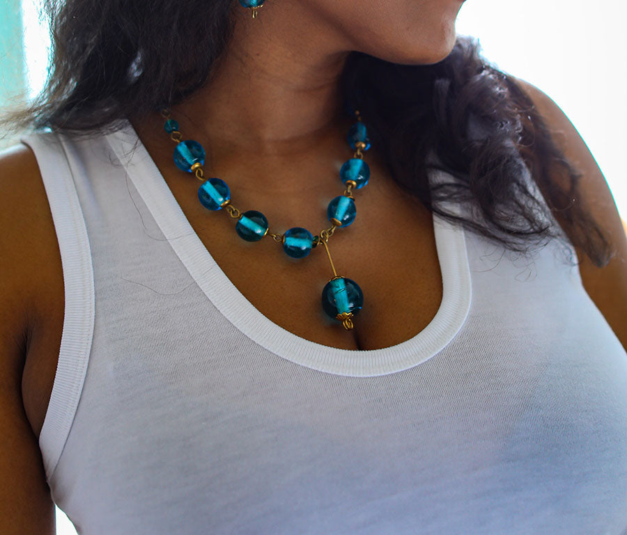 A beautifully handcrafted necklace made of recycled glass and brass