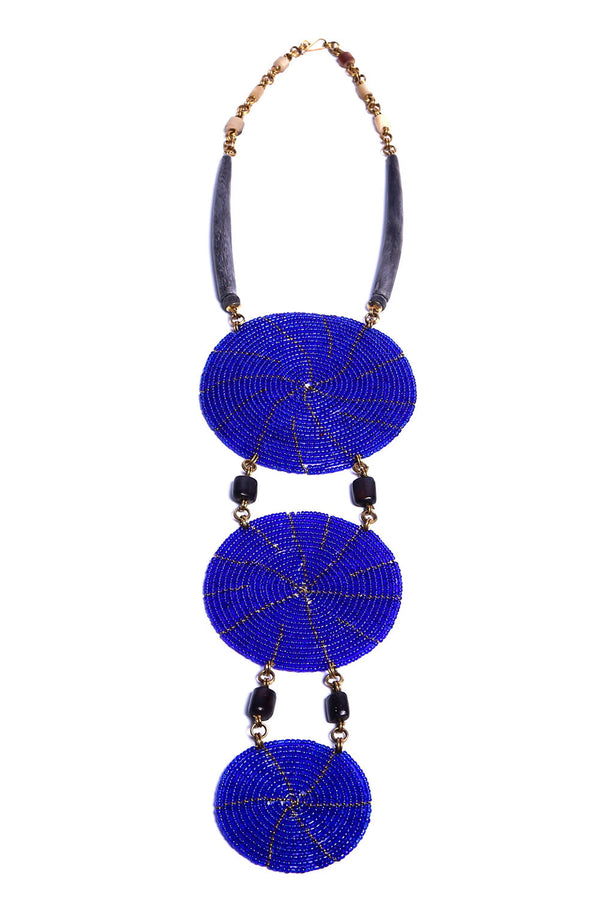 This stunning one-of-a-kind necklace features hundreds of blue glass beads each individually placed by hand, giving it a bold and striking design. Get lots of compliments on this unique and bold statement necklace.